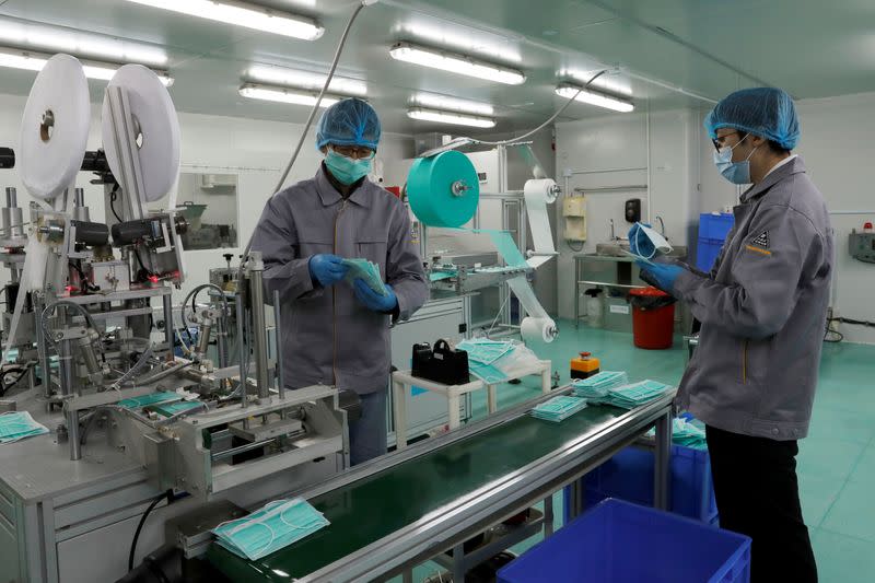 People work on a production line for prototype face masks at Mask Factory, following the outbreak of the new coronavirus, in Hong Kong