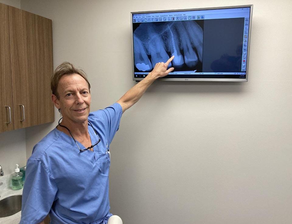 Erie endodontist Pat DeMarco points to root canal work he had done on his own teeth as he stands in a treatment room at his Erie office. DeMarco is the only endodontist, a dentist who specializes in root canals, currently seeing patients in the Erie area.