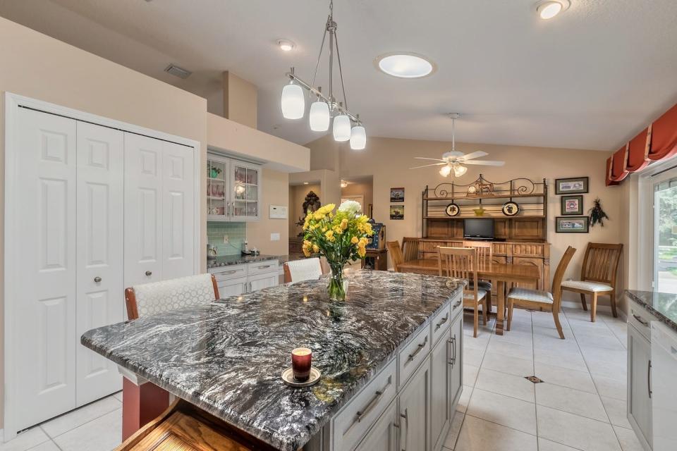 The charming open kitchen features custom cabinets (with easy open/close pull-out drawers), granite countertops and a beautiful 7-foot island.