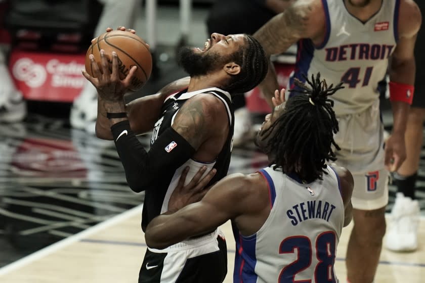 Detroit Pistons' Isaiah Stewart, right, fouls Los Angeles Clippers' Paul George during the first half of an NBA basketball game Sunday, April 11, 2021, in Los Angeles. (AP Photo/Jae C. Hong)