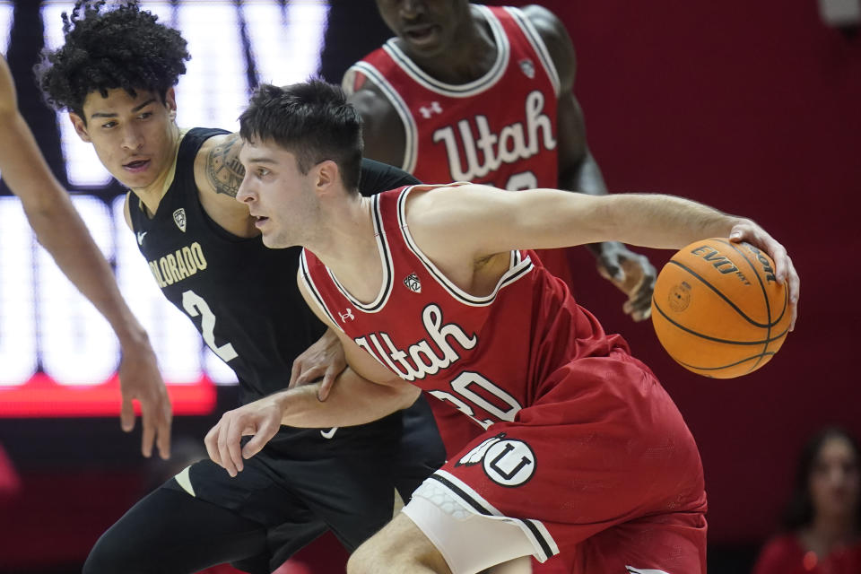 Utah guard Lazar Stefanovic (20) drives as Colorado guard KJ Simpson (2) defends during the first half of an NCAA college basketball game Saturday, Feb. 11, 2023, in Salt Lake City. (AP Photo/Rick Bowmer)