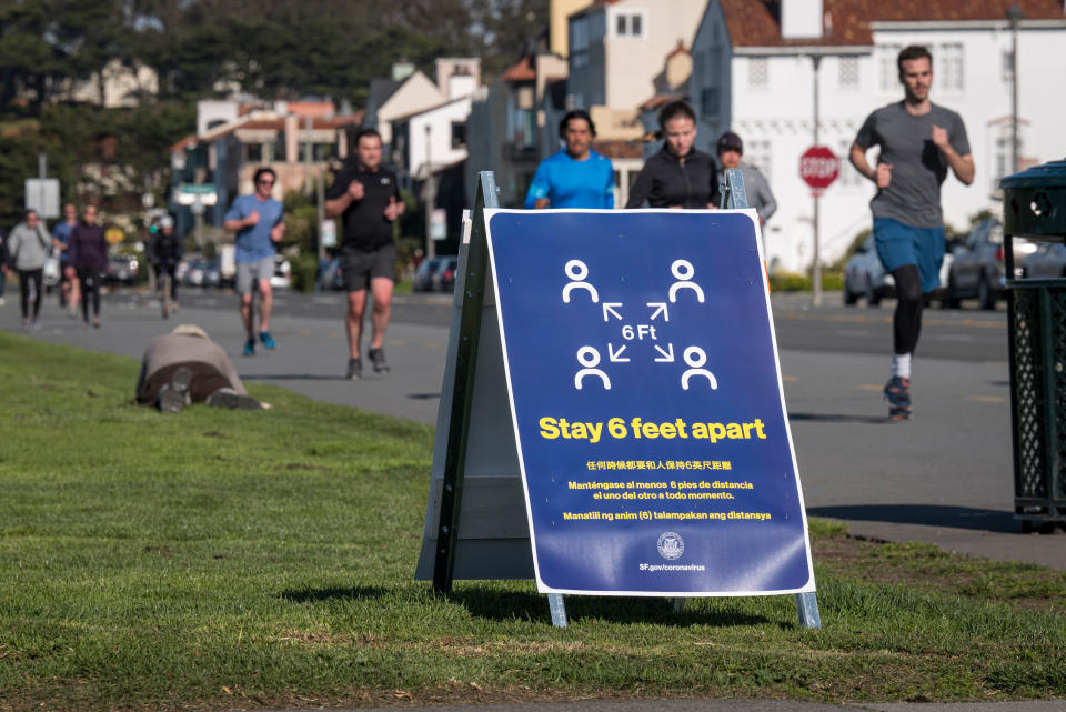 A sign informing people to stay 6 feet apart stands on Marina Boulevard at Marina Green in San Francisco, California on March 25, 2020. (David Paul Morris/Bloomberg via Getty Images)