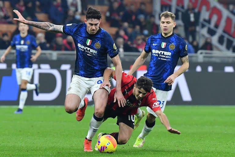 El mediocampista español del Milan, Brahim Diaz, pelea por el balón con el defensor italiano Alessandro Bastoni (izquierda) y el mediocampista italiano Nicolo Barella (derecha) durante el clásico de Milán