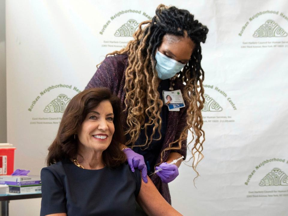 governor smiling as she receives a shot in the arm