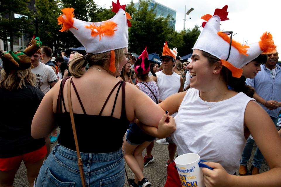Elizabeth Travnik, right, and McKenna Czekajlo dance together during "The World's Largest Chicken Dance" at Oktoberfest Zinzinnati on 2021.