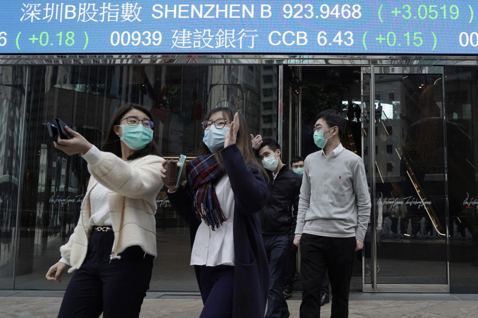 People wearing protective face masks, walk on a street in the Central, the business district of Hong Kong, Tuesday, Feb. 11, 2020. China's daily death toll from new virus has topped 100 for first time, with more than 1,000 total deaths recorded, the health ministry announced Tuesday, as the spread of the contagion shows little sign of abating while exacting an ever-rising cost. (AP Photo/Kin Cheung)