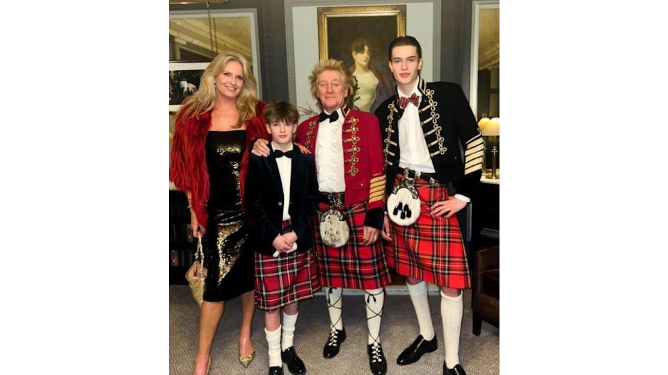 Penny Lancaster standing with Aiden Stewart, Rod Stewart and Alastair Stewart with the men in kilts