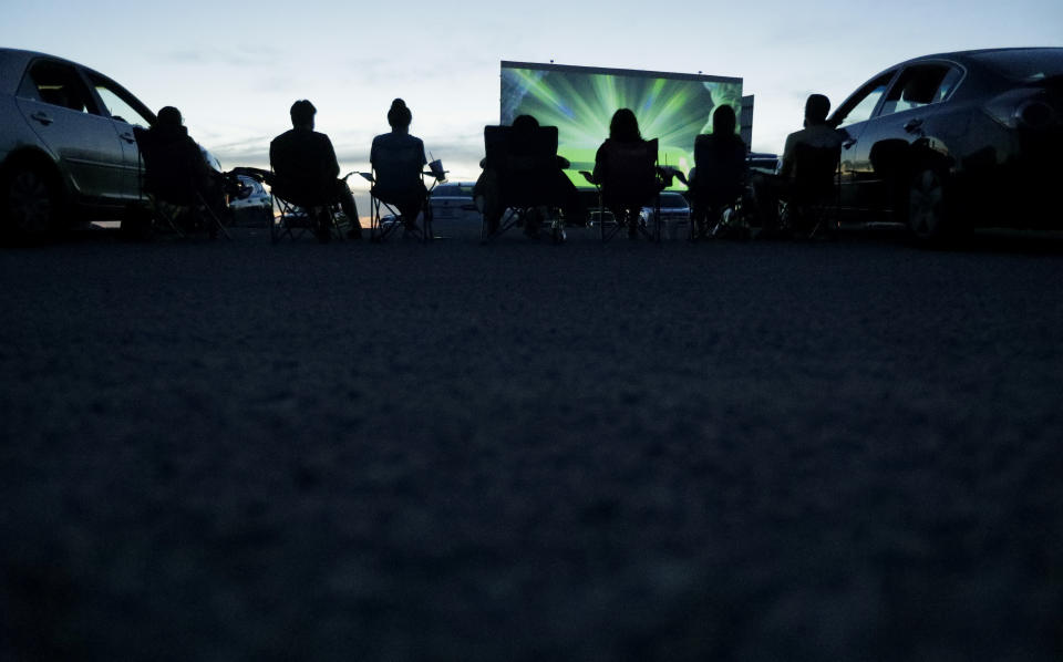 Using social distancing practices, moviegoers watch a show at the Stars and Stripes Drive-In Theater that reopened in New Braunfels, Texas, Friday, May 1, 2020. Texas' stay-at-home orders due to the new coronavirus pandemic have expired and Texas Gov. Greg Abbott has eased restrictions on many businesses that have now opened, including theaters. (AP Photo/Eric Gay)