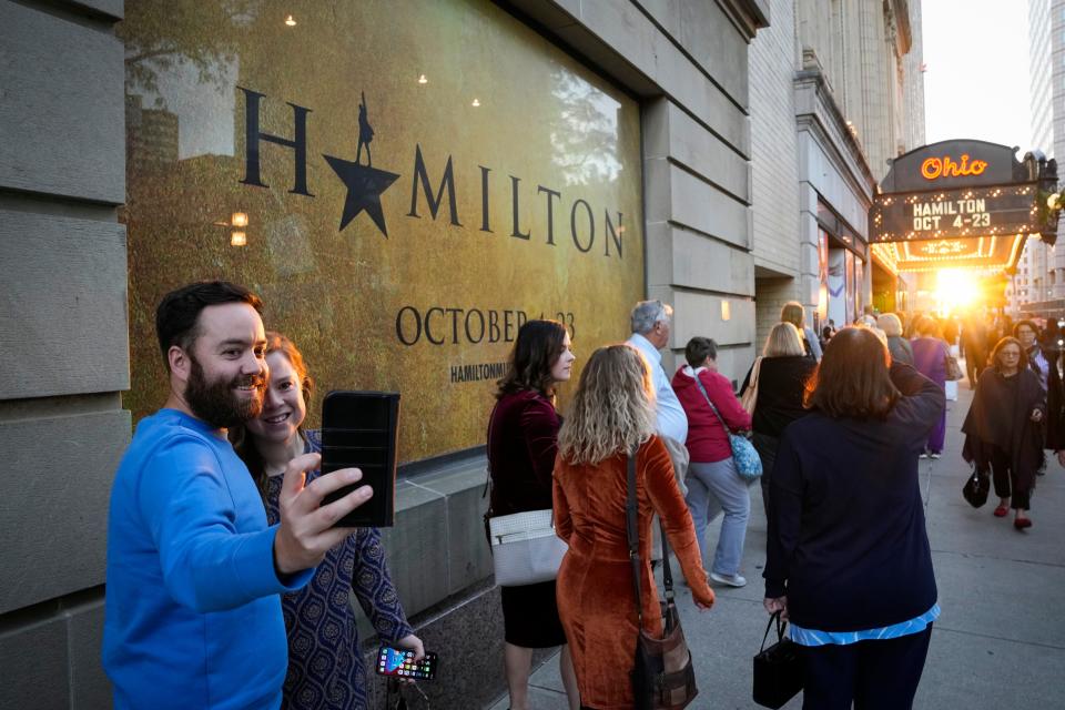 Matt Moore and Lindsey Thieken of German Village take a photo as visitors wait in line to get into the Ohio Theatre for the opening night of "Hamilton."