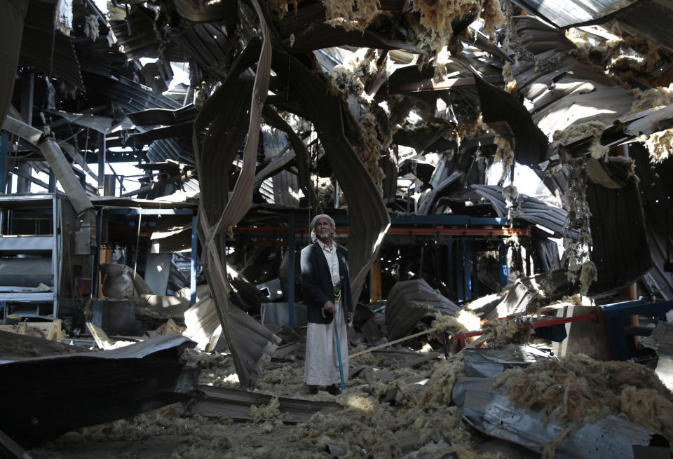 FILE - In this Sept. 22, 2016, file photo, a man stands among the rubble of the Alsonidar Group's water pump and pipe factory after it was hit by Saudi-led airstrikes in Sanaa, Yemen. The Saudi-led coalition fighting in Yemen said early Saturday, Nov. 10, 2018, it had "requested cessation of inflight refueling" by the U.S. for its fighter jets after American officials said they would stop the operations amid growing anger over civilian casualties from the kingdom's airstrikes. (AP Photo/Hani Mohammed, File)