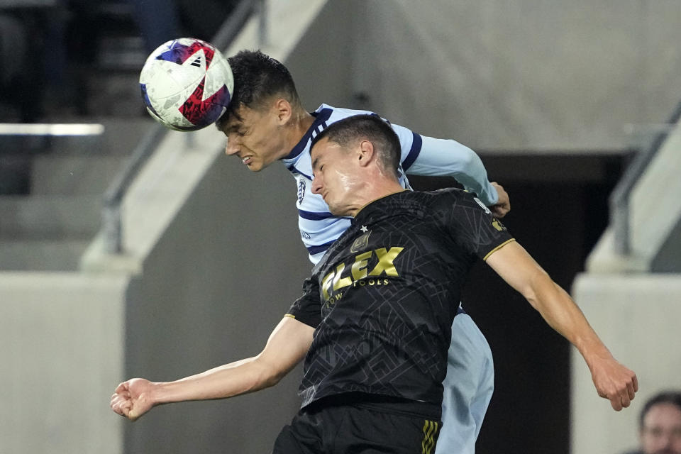 Sporting Kansas City forward Daniel Salloi, left, and Los Angeles FC defender Sergi Palencia try to head the ball during the first half of a Major League Soccer match Wednesday, May 17, 2023, in Los Angeles. (AP Photo/Mark J. Terrill)