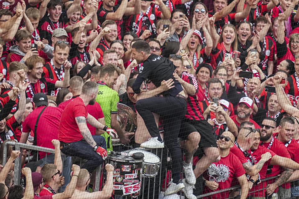 Leverkusen's head coach Xabi Alonso celebrates with fans as his team won the German Bundesliga, after the German Bundesliga soccer match between Bayer Leverkusen and FC Augsburg at the BayArena in Leverkusen, Germany, Saturday, May 18, 2024. Bayer Leverkusen have won the Bundesliga title for the first time. It is the first team in Bundesliga history, that won the championship unbeaten for the whole season. (AP Photo/Michael Probst)