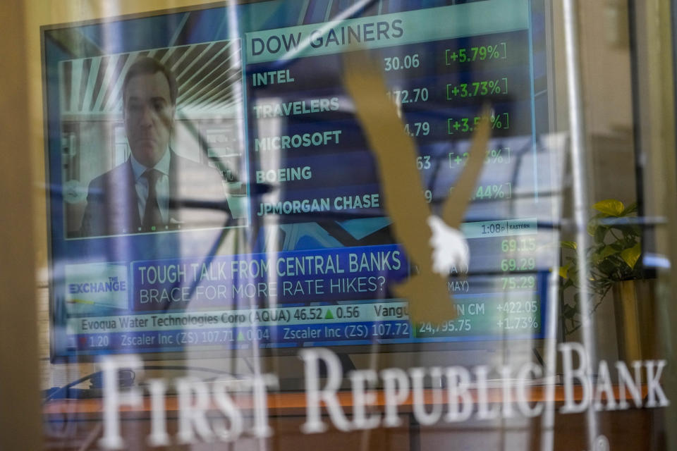 A television screen displaying financial news is seen inside one of First Republic Bank's branches in the Financial District of Manhattan, Thursday, March 16, 2023. The S&P 500 was 0.8% higher in midday trading after erasing an earlier loss of nearly that much following reports that First Republic Bank could receive financial assistance or sell itself to another bank. (AP Photo/Mary Altaffer)