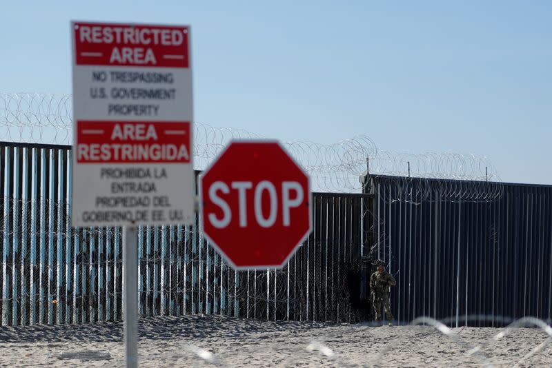 FILE PHOTO: An armed U.S. Customs and Border Patrol agent stands watch at the border fence next the the beach in Tijuana, at the Border State Park in San Diego, California