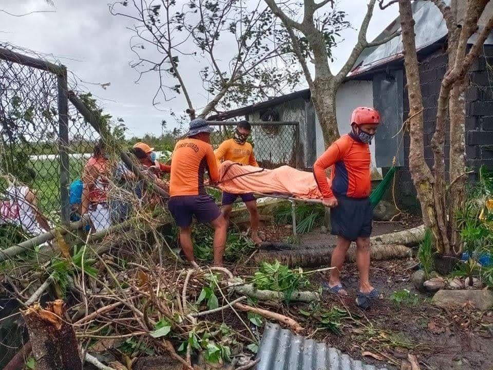 In this photo provided by the Philippine Coast Guard, rescuers carry the body of a man who drowned during floods brought about by Typhoon Goni in Camarines Sur province, eastern Philippines on Sunday Nov. 1, 2020. At least 16 people were killed as Typhoon Goni lashed the Philippines over the weekend, and about 13,000 shanties and houses were damaged or swept away in the eastern island province that was first hit by the ferocious storm, officials said Monday. (Philippine Coast Guard via AP)