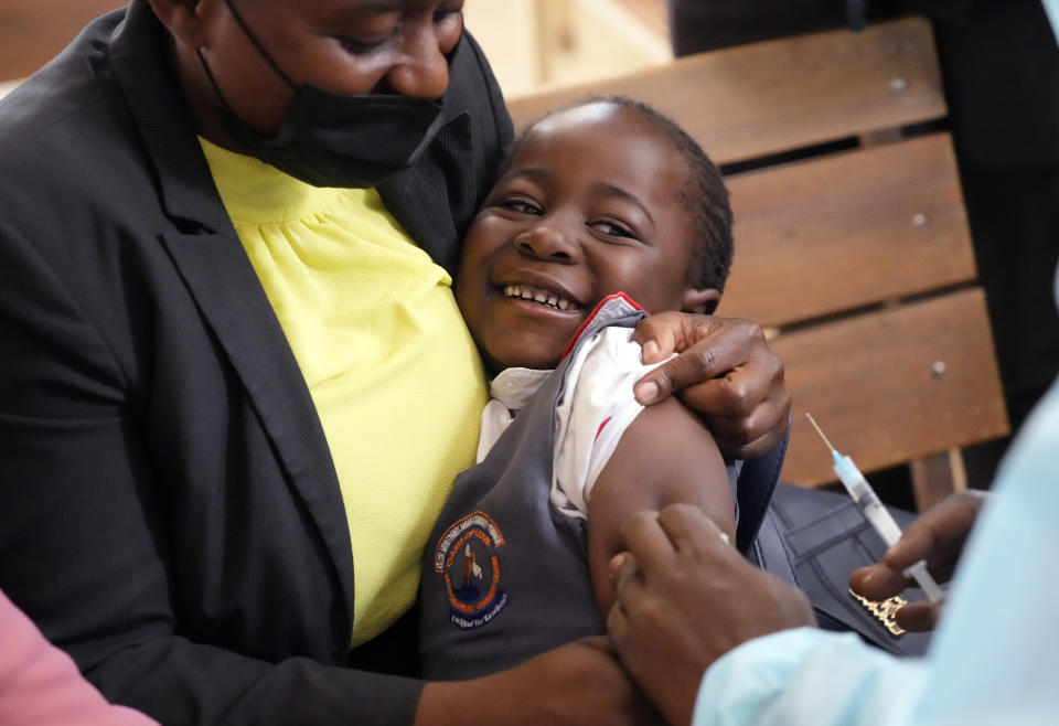 A young girl smiles while been vaccinated against measles at a clinic in Harare, Zimbabwe, Thursday, Sept. 15, 2022. Church members in Zimbabwe are getting their children vaccinated against measles in secret amid a deadly outbreak. It's to avoid being shunned by religious leaders who are opposed to modern medicine. (AP Photo/Tsvangirayi Mukwazhi)