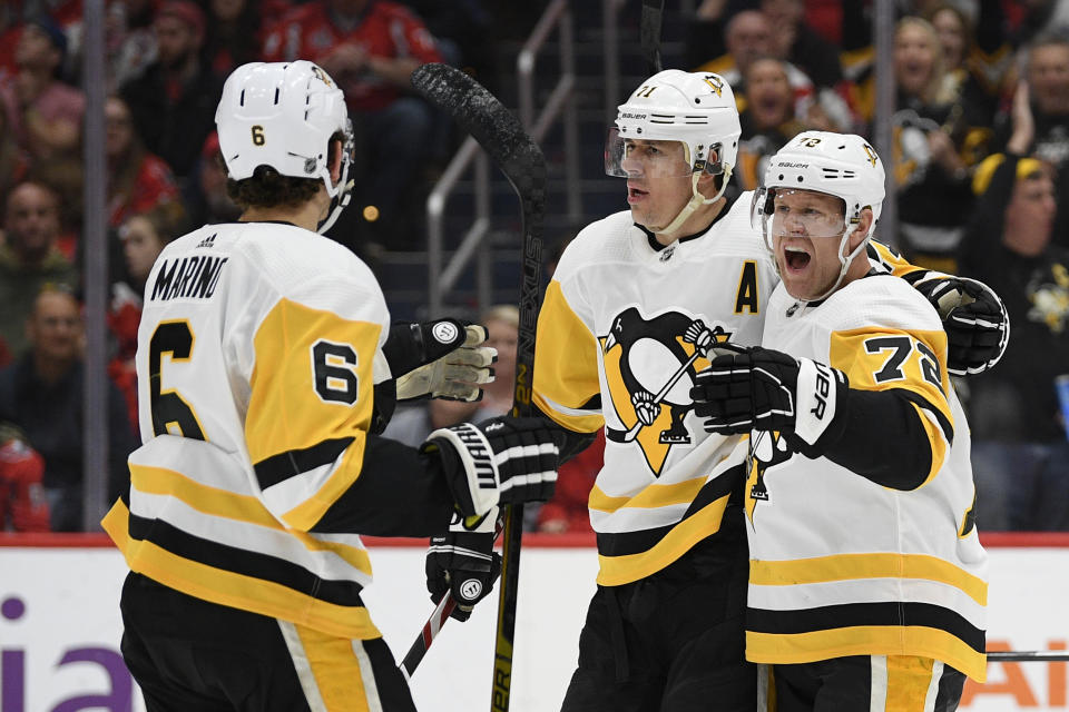 Pittsburgh Penguins right wing Patric Hornqvist (72) celebrates his goal with defenseman John Marino (6) and center Evgeni Malkin, center, during the first period of an NHL hockey game against the Washington Capitals, Sunday, Feb. 2, 2020, in Washington. (AP Photo/Nick Wass)