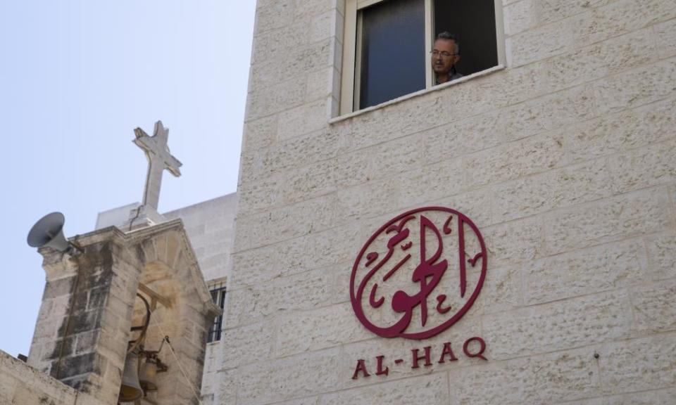 A man looks out of the window of the office of Al-Haq after it was raided in the West Bank city of Ramallah