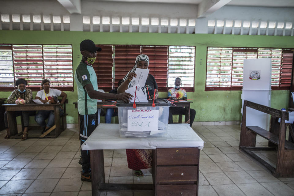 A woman votes at a school in Conakry, Guinea, Sunday Oct. 18, 2020. Guineans head to the polls to elect their president, choosing between incumbent Alpha Conde who is seeking a third term and historical opponent Cellou Dalein Diallo. (AP Photo/Sadak Souici)