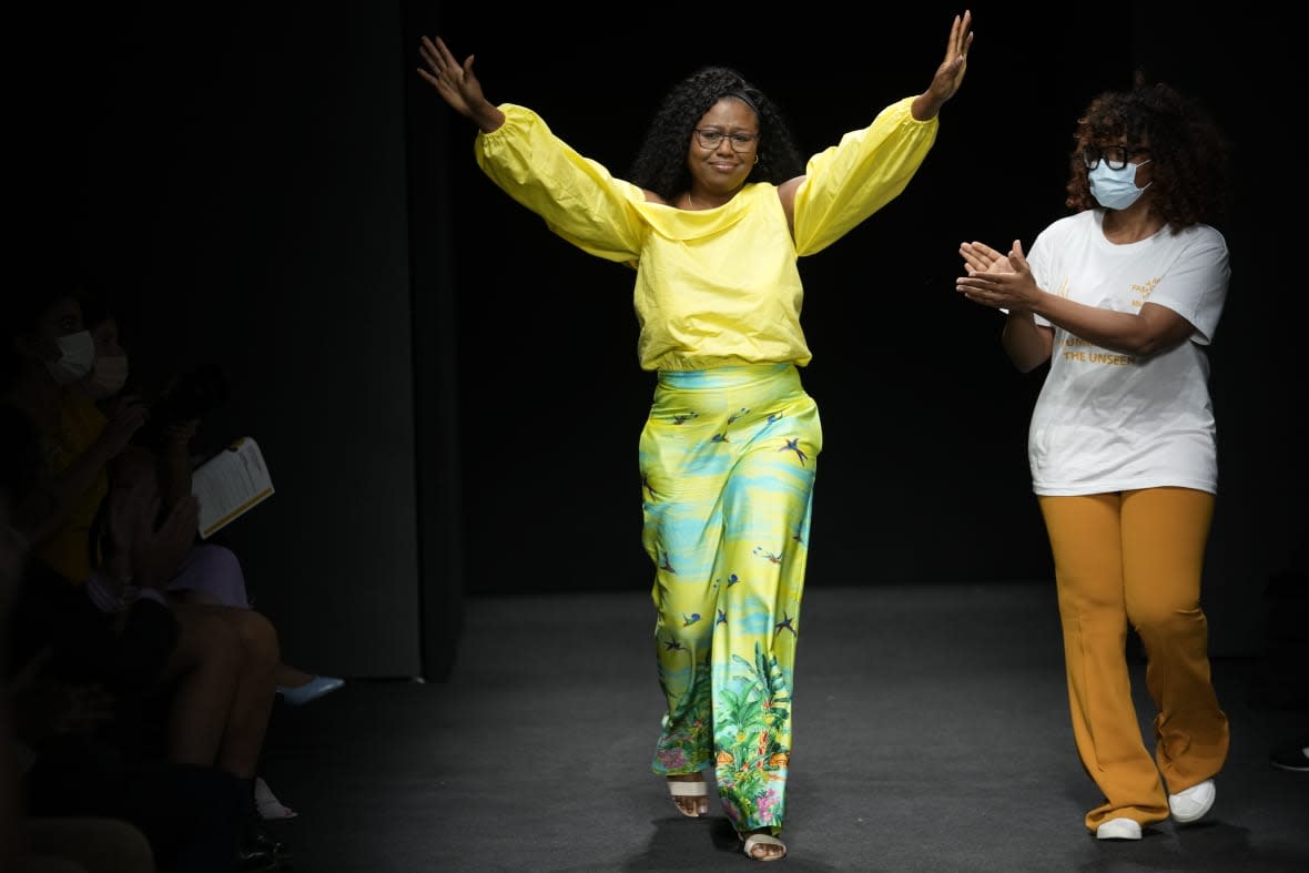 Designer Joy Meribe acknowledges the applause at the end of her Spring Summer 2022 collection, unveiled during the Milan Fashion Week, in Milan, Italy, on Sept. 22, 2021. (AP Photo/Luca Bruno, File)
