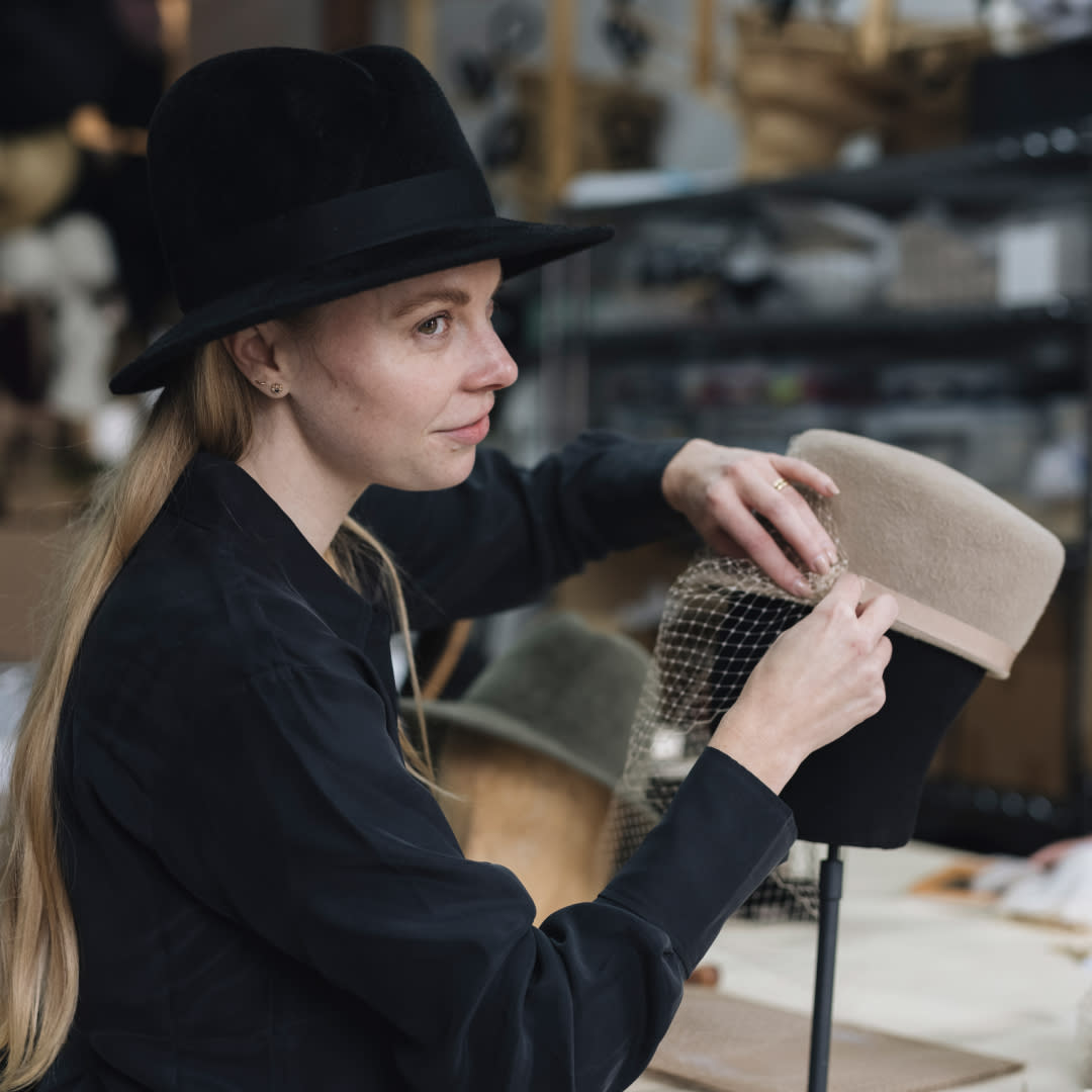  Hat-maker Gigi Burris attaching a veil to a felt cap. 