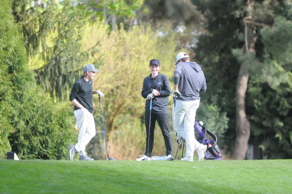 South Eugene's Owen Davis-Piger, center, shares a smile with Sheldon's Tim Morach, left, and Grants Pass' Carson Krauss, right, in the boys high school invitational at Eugene Country Club in Eugene on April 15, 2024.