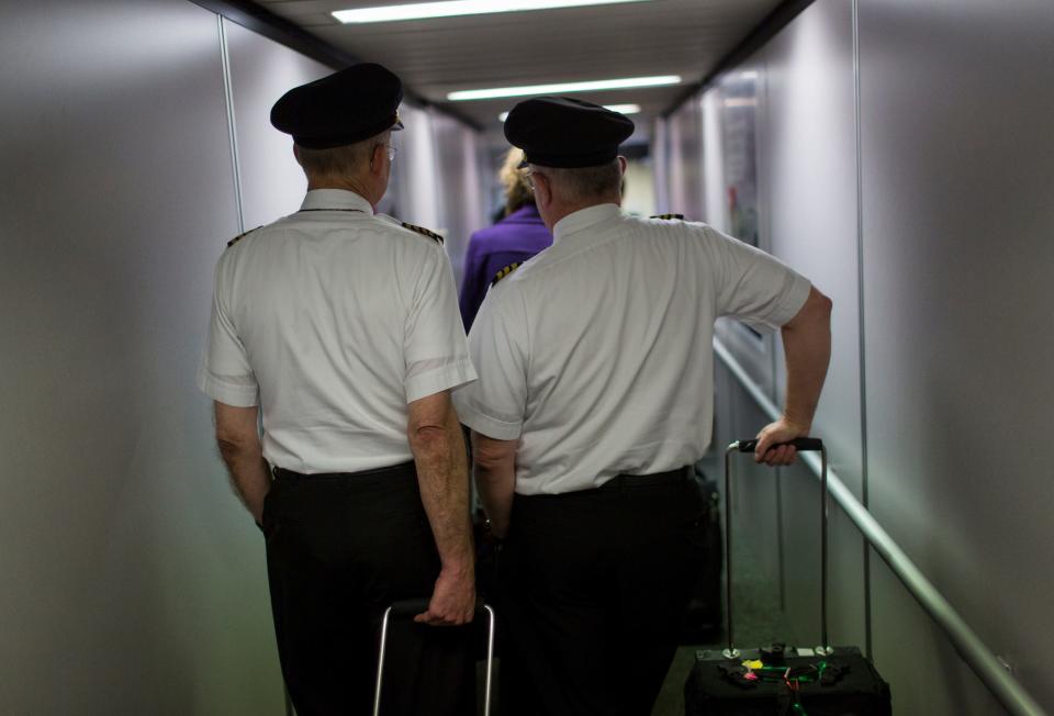 Two Delta Air Lines pilots wait to board a plane April 16, 2014 at the Minneapolis-St Paul International Airport in Minneapolis, Minnesota.