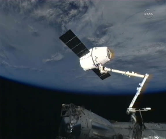 A SpaceX Dragon cargo capsule is perched at the end of the International Space Station's robotic arm after being grappled by astronauts on March 3, 2013, during the CRS-2 (SpaceX 2) cargo delivery mission.
