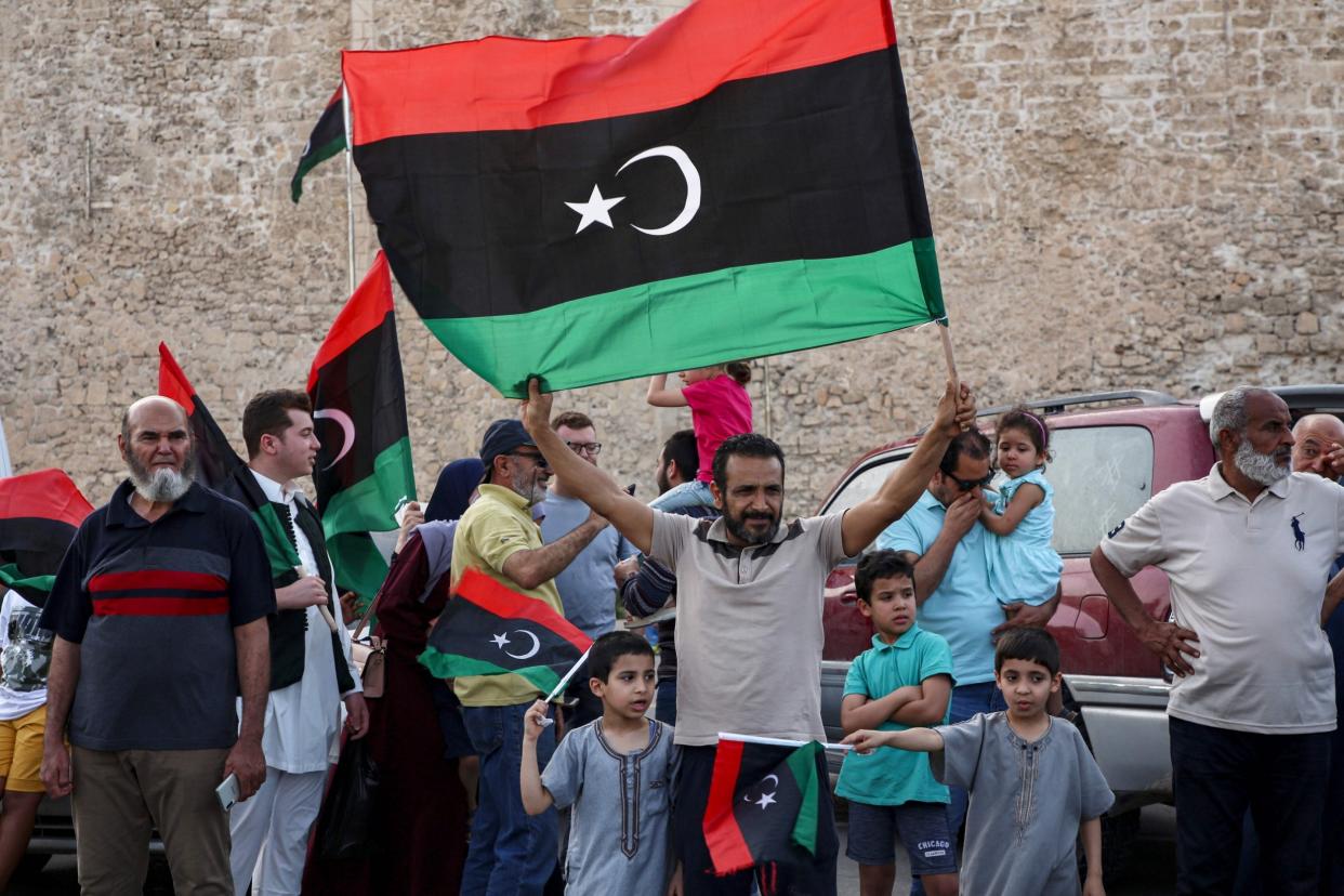 A man waves a Libyan national flag as people celebrate in Tripoli: AFP via Getty Images