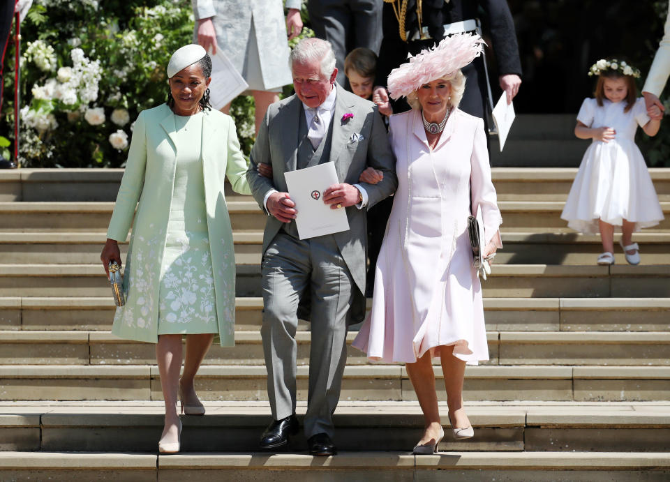 Charles walks arm-in-arm down the steps outside the chapel with both Ragland (left) and Camilla (right).&nbsp;