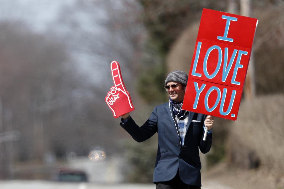 FILE - In this Wednesday, April 8, 2020 file photo, Sam Mawhinney does his best to bring a moments of joy to motorists as spreads his message of love while walking in Cape Elizabeth, Maine. (AP Photo/Robert F. Bukaty)