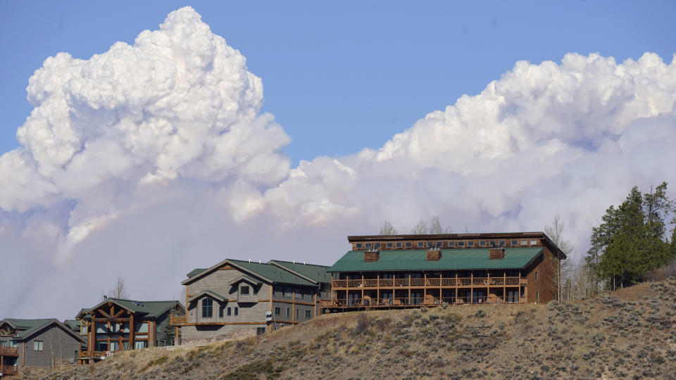 Smoke rises from mountain ridges over homes as a wildfire burns Thursday, Oct. 22, 2020, in this view from Fraser, Colo. (AP Photo/David Zalubowski)