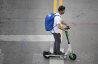 As temperatures soar into the triple digits for the third straight day, a man uses a scooter to move along 20th Street Thursday, June 17, 2021, in Denver. (AP Photo/David Zalubowski)