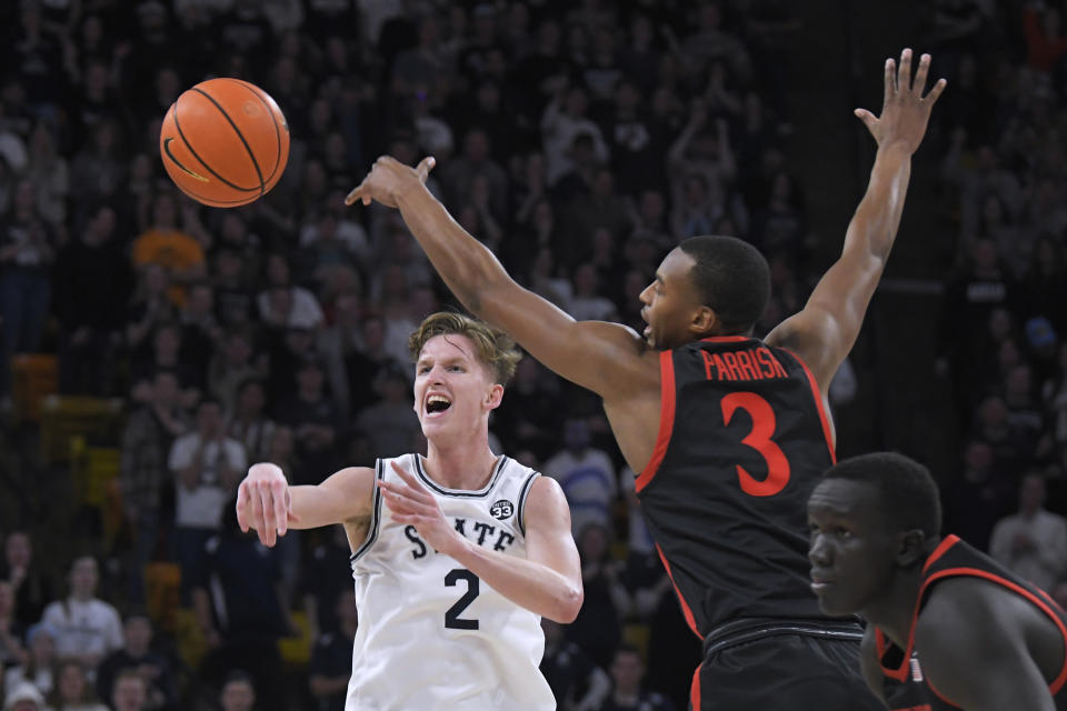 Utah State guard Sean Bairstow (2) passes the ball as San Diego State guard Micah Parrish (3) defends during the second half of an NCAA college basketball game Wednesday, Feb. 8, 2023, in Logan, Utah. (AP Photo/Eli Lucero)