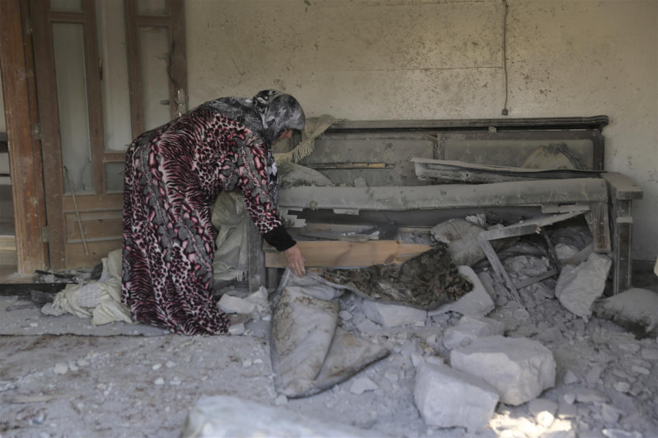A woman checks damage to her home in the village of Barisha, in Idlib province, Syria, Sunday, Oct. 27, 2019, after an operation by the U.S. military which targeted Abu Bakr al-Baghdadi, the shadowy leader of the Islamic State group. President Donald Trump says Abu Bakr al-Baghdadi is dead after a U.S. military operation in Syria targeted the Islamic State group leader. (AP Photo/ Ghaith Alsayed)
