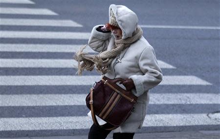 A woman reacts to strong wind caused by hurricane-force Xaver in Lodz central Poland, December 6, 2013. REUTERS/Kacper Pempel