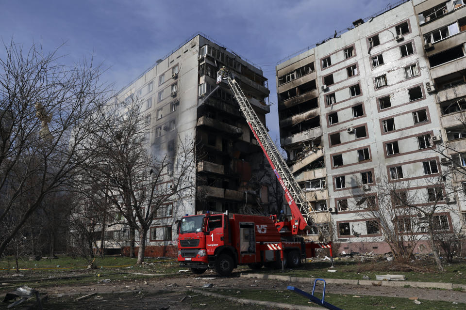 A firefighter puts out a fire after a Russian missile hit a residential multi-story building in southeastern city of Zaporizhzhia, Ukraine, Wednesday, March 22, 2023. (AP Photo/Kateryna Klochko)