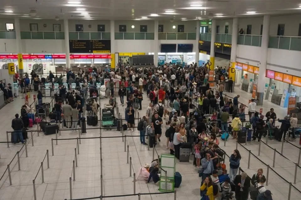 Varias personas esperan junto a los mostradores de facturación del aeropuerto de Gatwick, nombrado el más estresante del mundo. (Forbes)