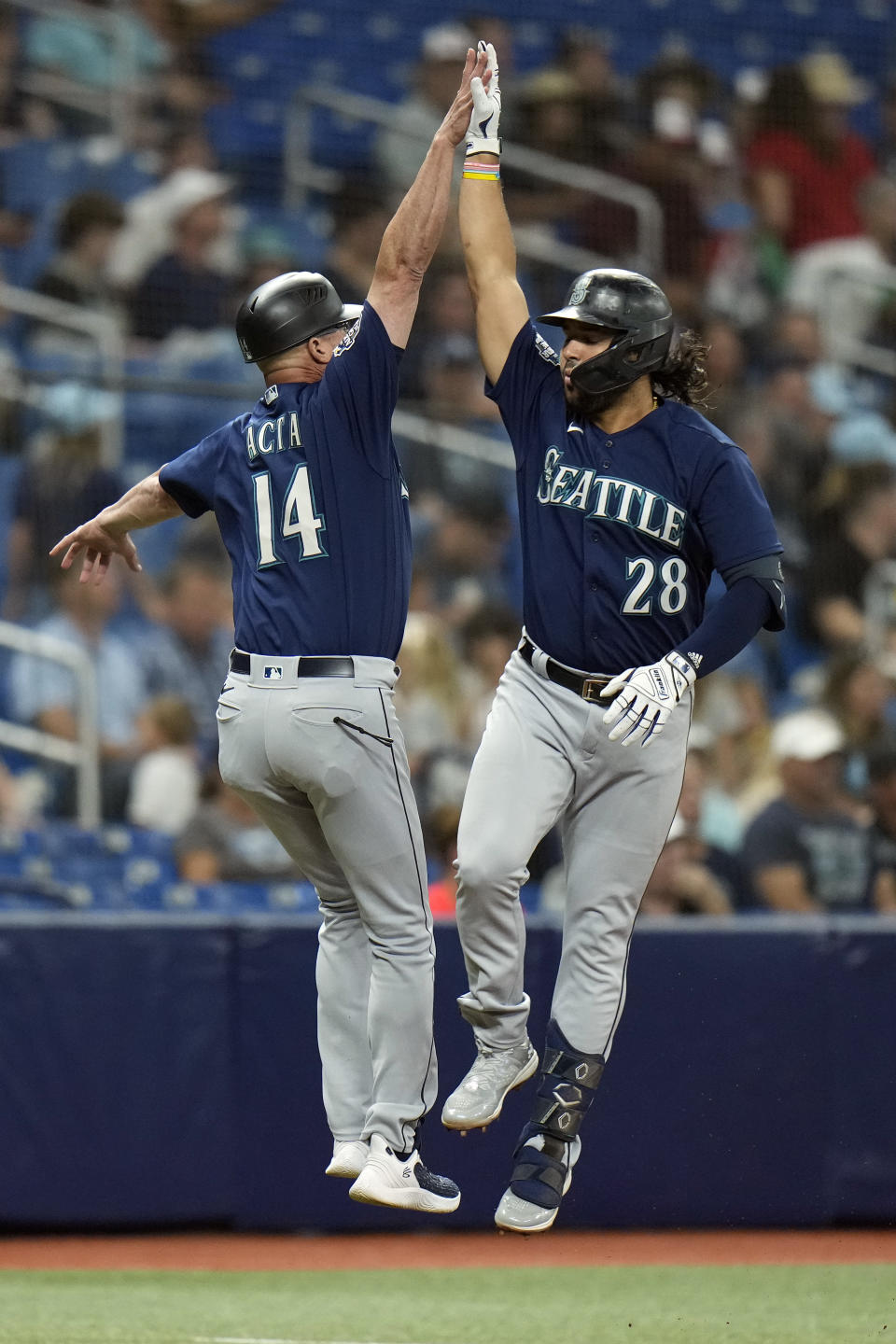 Seattle Mariners' Eugenio Suarez (28) celebrates with third base coach Manny Acta (14) after hitting a home run off Tampa Bay Rays starting pitcher Taj Bradley during the second inning of a baseball game Friday, Sept. 8, 2023, in St. Petersburg, Fla. (AP Photo/Chris O'Meara)