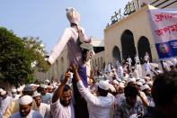 Supporters of Islami Oikya Jote, an Islamist political party, hold up an effigy representing French President Emmanuel Macron during a protest against the publishing of caricatures of the Prophet Muhammad they deem blasphemous, in Dhaka, Bangladesh, Wednesday, Oct. 28, 2020. Muslims in the Middle East and beyond on Monday called for boycotts of French products and for protests over the caricatures, but Macron has vowed his country will not back down from its secular ideals and defense of free speech. Posters read "France is the enemy of humanity. World citizens fight back." second left, "Muslims of the world stand against insults to the prophet," third right and "Stop buying products from France. In the name of the Prophet," left. (AP Photo/Mahmud Hossain Opu)