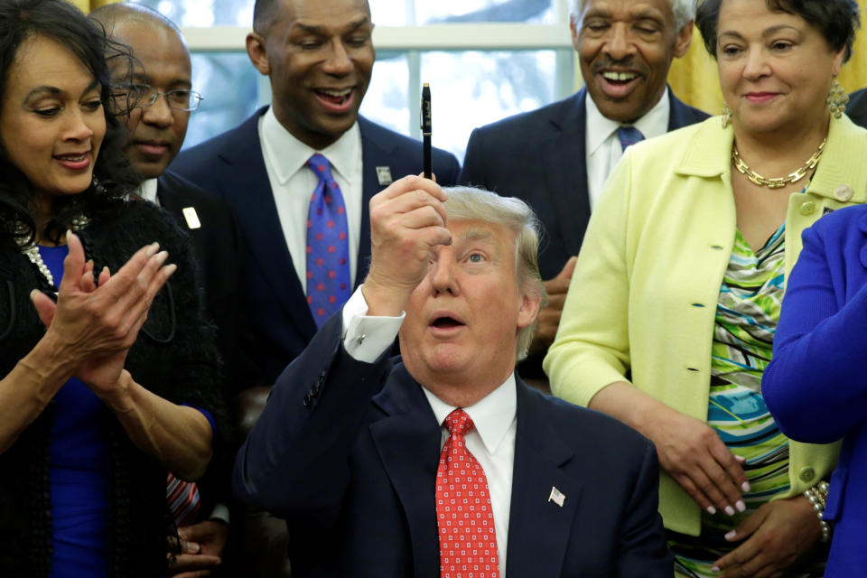 President Donald Trump holds up a pen after signing the HBCU executive order in the Oval Office of the White House, in Washington, DC on Feb. 28, 2017.&nbsp;