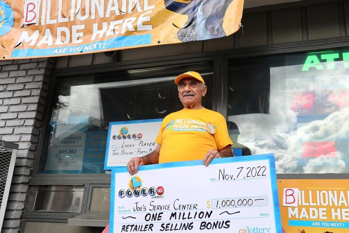 Business owner Joe Chahayed holds a Powerball bonus check outside Joe's Service Center that sold the winning Powerball ticket of 2.04 billion US dollars in Altadena, California, the United States, on Nov. 8, 2022.