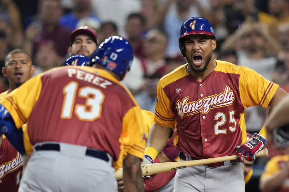 Venezuela's Anthony Santander (25) celebrates with Salvador Perez (13) after Perez hit a home run scoring Jose Altuve and Luis Arraez during the second inning of a World Baseball Classic game against Puerto Rico, Sunday, March 12, 2023, in Miami. (AP Photo/Wilfredo Lee)