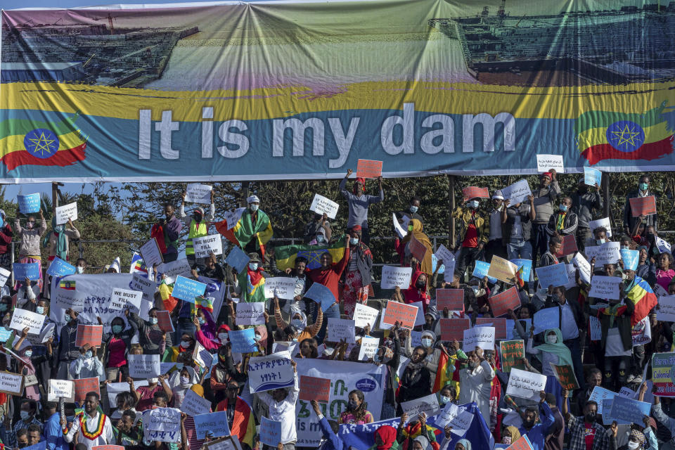 Ethiopians protest against international pressure on the government over the conflict in Tigray, below a banner referring to The Grand Ethiopian Renaissance Dam, at a demonstration organised by the city mayor's office held at a stadium in the capital Addis Ababa, Ethiopia Sunday, May 30, 2021. Thousands of Ethiopians gathered Sunday to protest outside pressure on the government over its brutal war in Tigray, after the U.S. said last week it has started restricting visas for government and military officials of Ethiopia and Eritrea who are seen as undermining efforts to resolve the fighting. (AP Photo/Mulugeta Ayene)