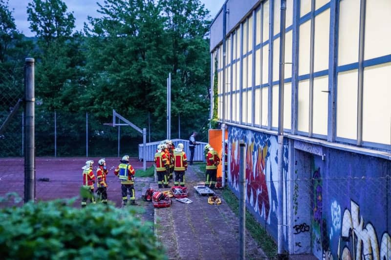 Rescue workers stand in front of a gymnasium. Four children fell through the roof of a sports hall and were seriously injured.  They probably fell through the skylight of the roof while playing. Kohls/SDMG/dpa