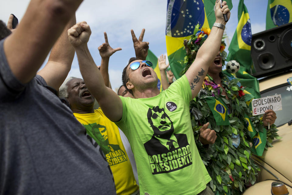 Supporters of Jair Bolsonaro, presidential candidate with the Social Liberal Party, sing the national anthem in front of his house during the presidential runoff election, in Rio de Janeiro, Brazil, Sunday, Oct. 28, 2018. Bolsonaro is running against leftist candidate Fernando Haddad of the Workers' Party. (AP Photo/Silvia Izquierdo)