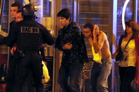 French special forces evacuate people, including an injured man holding his head, as people gather near the Bataclan concert hall following fatal shootings in Paris, France, November 13, 2015. REUTERS/Christian Hartmann