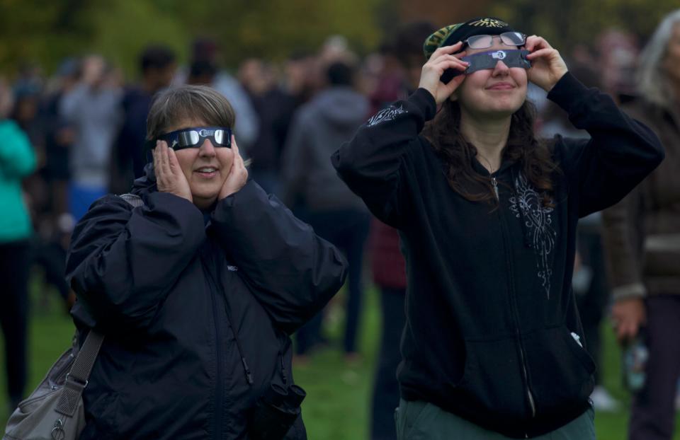 Sonja Drapela, left, and Abigail Backman view the annular eclipse through their glasses at the Eugene Science Center on Saturday, Oct. 14, 2023.