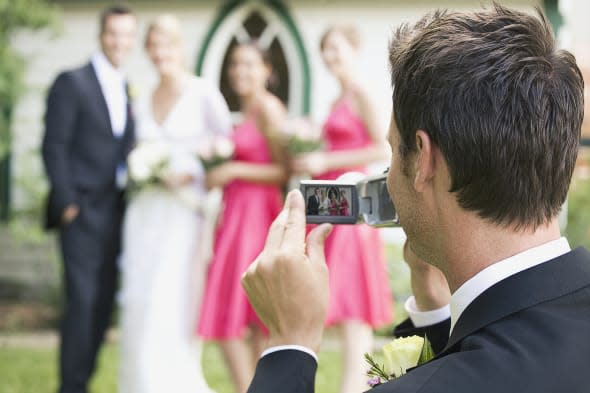Man photographing wedding party Image by:  Marnie Burkhart/Corbis