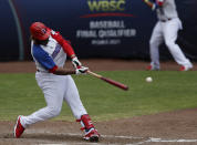 Dominican Republic outfielder Johan Mieses connects a single against Venezuela during a final Olympic baseball qualifier game, in Puebla, Mexico, Saturday, June 26, 2021. (AP Photo/Fernando Llano)